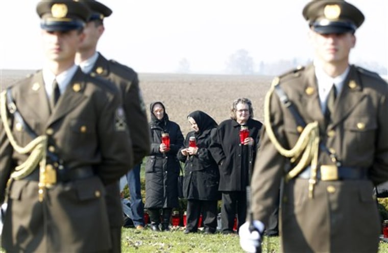 Croatian guards of honor stand in front of family members of 1991 war victims on Thursday before Serbian President Boris Tadic visits a farm where more than 200 Croats dragged out of a local hospital were slain by Serbs.